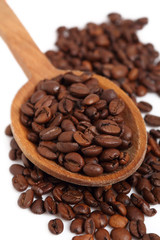 Coffee beans on wooden spoon. Isolated on white background. Macro.