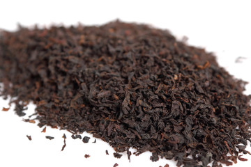 Loose dried black tea leaves. Isolated on white background. Macro.