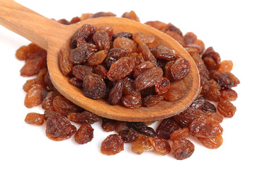 Raisins on wooden spoon. Isolated on white background.