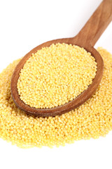 Millet Grains on wooden spoon. Isolated on white background.