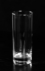 Empty highball glass at black background