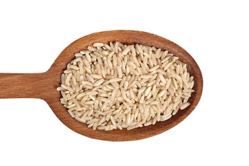 Long grain brown rice on wooden spoon. Isolated on white background. Directly Above.