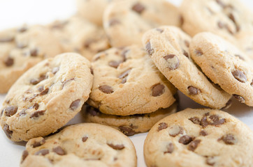 Close up on cookies with dark chocolate chips on the white background. Dessert or pastries
