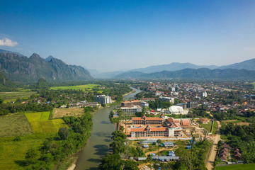 Fototapeta na wymiar Aerial view of village Vang Vieng and Nam Song river , Laos. Southeast Asia. Photo made by drone from above. Bird eye view.