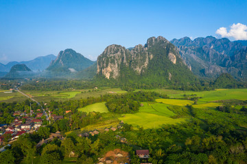 Fototapeta na wymiar Aerial view of village Vang Vieng and Nam Song rive , Laos. Southeast Asia. Photo made by drone from above. Bird eye view.