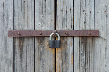 Fragment of a wooden door closed on a padlock
