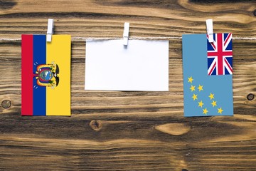 Hanging flags of Ecuador and Tuvalu attached to rope with clothes pins with copy space on white...