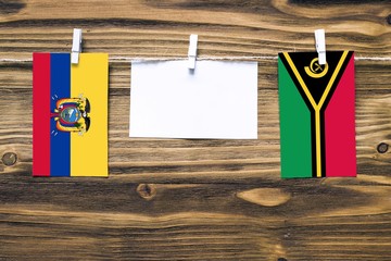 Hanging flags of Ecuador and Vanuatu attached to rope with clothes pins with copy space on white...