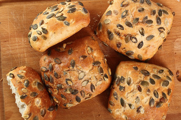 Pumpkin seed bread roll on cutting board. Directly Above.