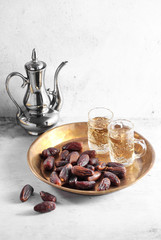 dates fruit and Arab tea on a white concrete background with a blank space for a text, dates fruit on a white background