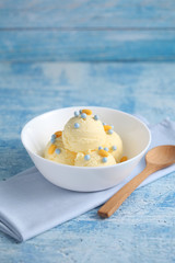 vanilla ice cream and candy on a blue background with a blank space for a text, vanilla ice cream in white ceramic cup