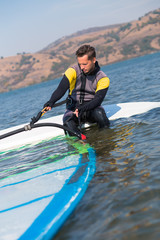 Young man preparing for windsurfing.