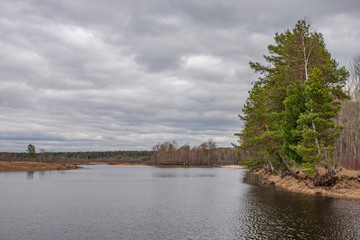 Spring landscape, forest, river, lake, cloudy day, storm clouds.