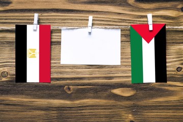 Hanging flags of Egypt and Palestine attached to rope with clothes pins with copy space on white...