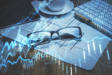 Financial chart hologram with glasses on the table background. Concept of business. Double exposure.
