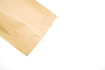 Brown paper bag on wooden white background with empty space for text. Flat lay, top view.