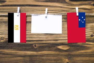Hanging flags of Egypt and Samoa attached to rope with clothes pins with copy space on white note...