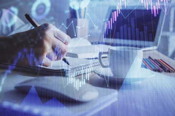 Financial chart drawn over hands taking notes background. Concept of research. Double exposure