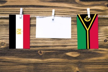 Hanging flags of Egypt and Vanuatu attached to rope with clothes pins with copy space on white note...