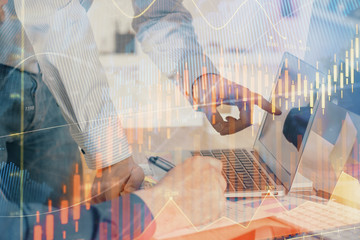 Double exposure of chart with businessman typing on computer in office on background. Concept of...