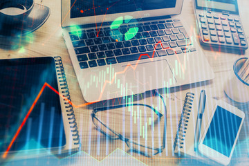 Financial chart drawing and table with computer on background. Double exposure. Concept of international markets.