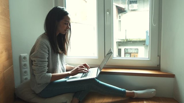 Young woman working over laptop at home