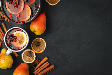 Top view of  hot mulled wine and spices on black background