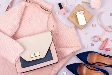 Flat lay of woman clothing and accessories in pastel colors