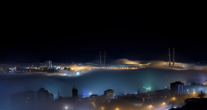 Vladivostok cityscape night view. Fog over the city.