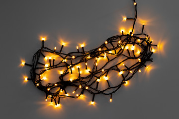 Glowing golden electric garland on a gray background © fotofabrika