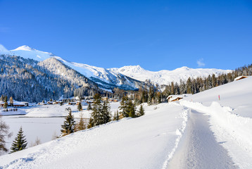 Landscape of lake Davos, covered by ice, in winter resort Davos, Switzerland.