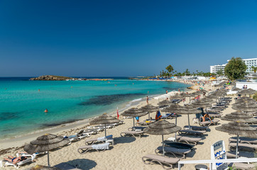 Fototapeta na wymiar Tourists relax on the famous beach of Cyprus. Nissi Beach