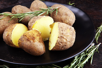 Pile of potatoes lying on a dish. Fresh boiled half potato and rosemary