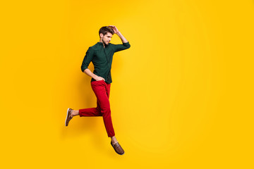 Fototapeta na wymiar Turned ful llength body size photo of serious fashionable man with hand in red pants pocket running for sales towards barbershop for cheap service isolated vibrant color background