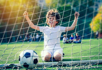 Soccer ball in goal on green grass. Disappointed football team goalkeeper following goals. Goalkeeper emotionally reacts after missed goal during game. Defeat Concept. selective focus