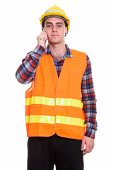 Portrait of young handsome man construction worker talking on the phone