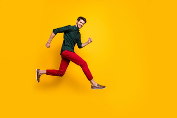 Fototapeta na wymiar Full length body size side profile photo of cheerful positive nice handsome man in green shirt running to empty space smiling toothily isolated vibrant color background