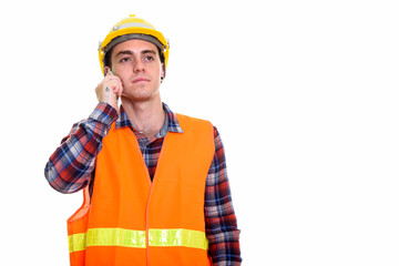 Young man construction worker thinking while talking on the phone