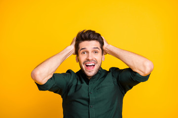 Fototapeta na wymiar Photo of cheerful ecstatic rejoicing man holding his head knowing new positive information being employed where he always wanted screaming with excited facial expression isolated over yellow vivid