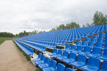 Fototapeta premium Fans stands with blue chairs. Tribunes bleachers