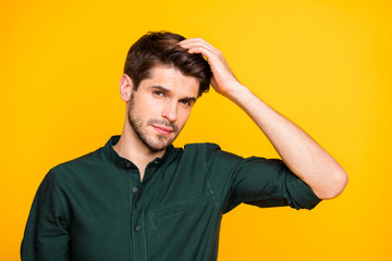Close up photo of virile confident man touching his hair worried about its falling off isolated over vivid color yellow background