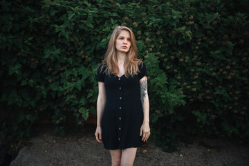 Romantic girl in black dress on green vegetative background