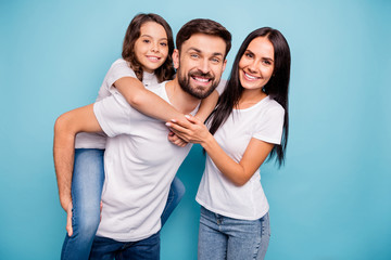 Portrait of positive cheerful funky three people carry kid piggyback enjoy weekends wear white t-shirt denim jeans denim isolated over blue color background