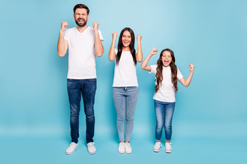Fototapeta premium Full body photo of funky three people champion mommy daddy kid brunette hair celebrate victory raise fists scream yeah wear white t-shirt denim jeans sneakers isolated over blue color background
