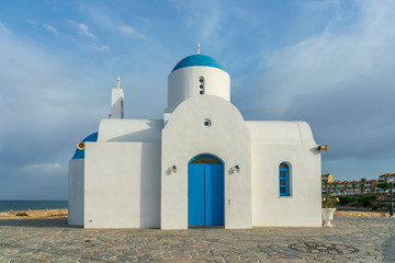Fototapeta na wymiar The picturesque Orthodox temple, built in the Greek style, is located on the coast of Cyprus.