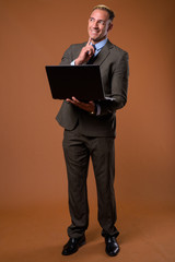 Full body shot of businessman using laptop computer