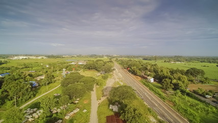 Fototapeta na wymiar Aerial view above railroad around with green green and cloudy sky background, Nong Kop, Ban Pong, Ratchaburi, Thailand.