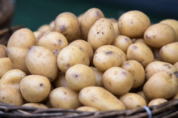 Raw potatoes in baskets on the market close up shot