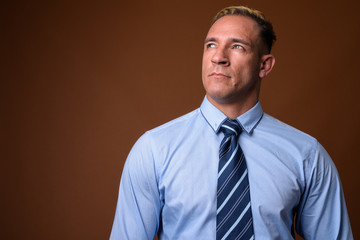 Studio shot of businessman thinking against brown background