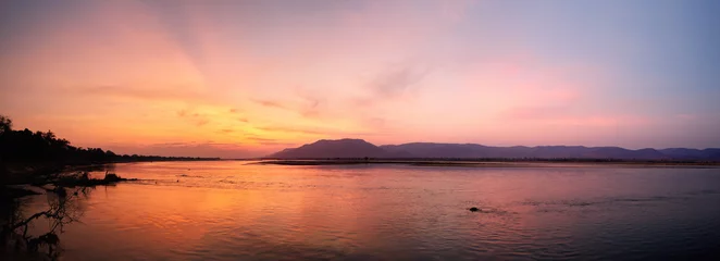 Foto op Aluminium Panoramic view of sunset on the african Zambezi river. The dramatic, red sky reflects on the surface of the border river. View over the flood plain to the mountains on the Zambian side of the river. © Martin Mecnarowski